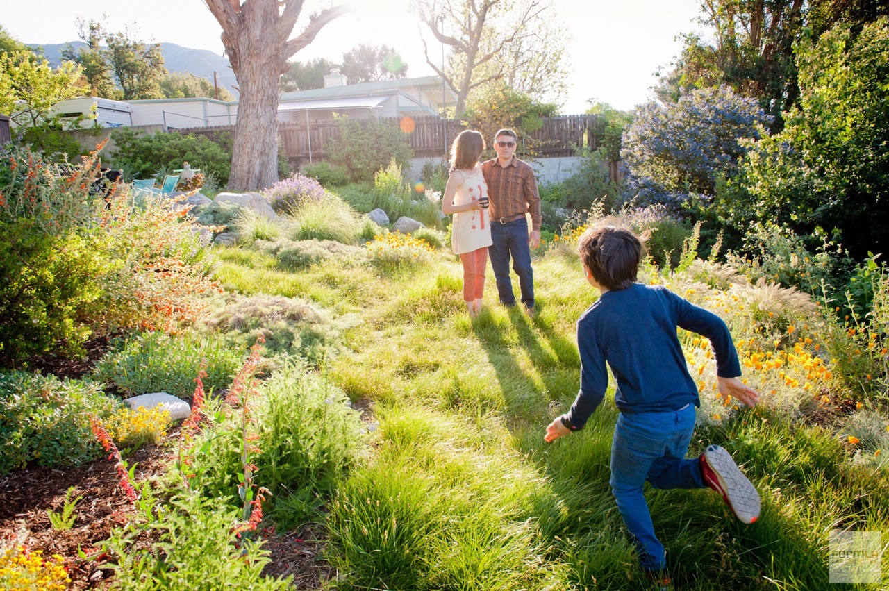 A child runs through a verdant meadow toward his parents.